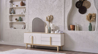 White dresser with wooden legs in a room with shelves and decorative items.