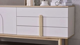 White dresser with wooden accents against a neutral wall