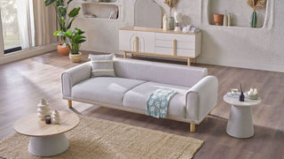 Modern living room with a white sofa, coffee table, and decorative items.