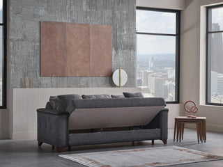 Gray sofa bed in a modern living room with large windows and cityscape view.