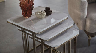 Set of marble tables with decorative items on a neutral background.
