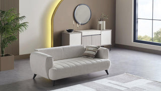 Modern living room with a sofa, decorative pillows, and a stylish mirror.