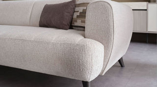 Beige sofa with patterned cushions in a room setting