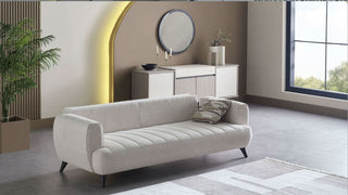 Mona sofa in a modern living room with a mirror and decorative items.