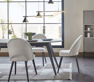 Modern dining room with a table and chairs near large windows.