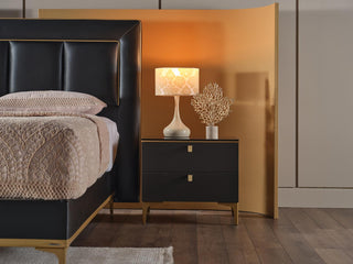 Close-up of the Carlino Bedroom Set showcasing polished gold-tone metal accents on gray surfaces.
