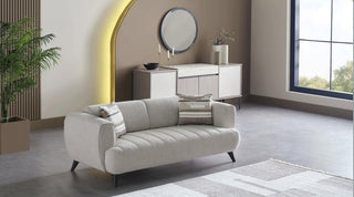 Modern living room with a sofa, decorative pillows, and a large window.